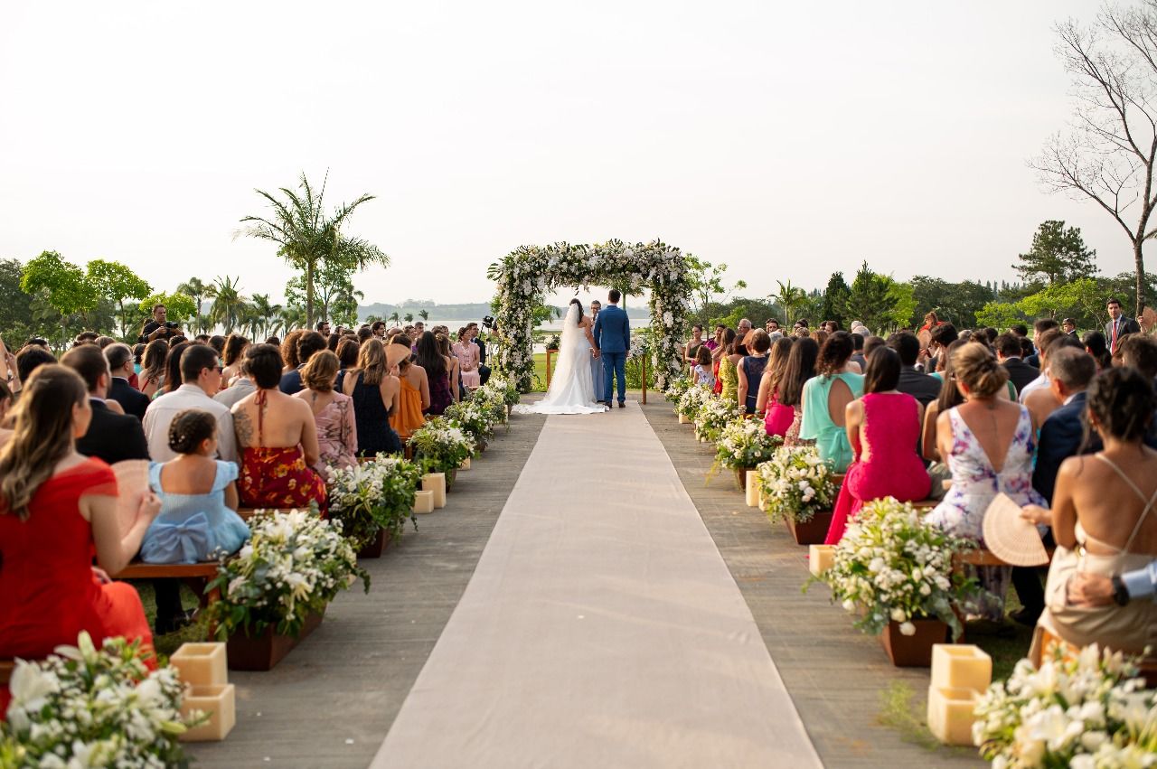 Cerimônia de destination wedding ao ar livre com convidados ao pôr do sol